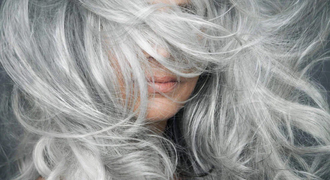 woman-with-grey-hair-blowing-across-her-face